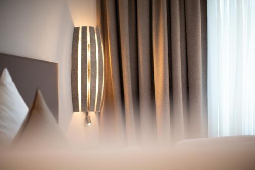a light hanging over a bed next to a window at A Casa Elements in Serfaus
