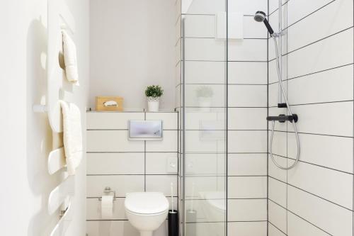 a white bathroom with a shower and a toilet at Hotel Alte Mühle in Chemnitz