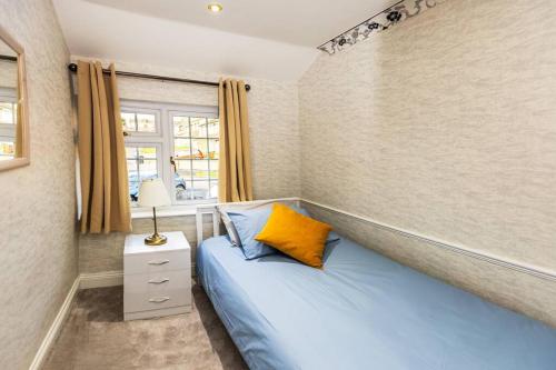 een slaapkamer met een blauw bed en een raam bij Comfy Home- Coley Park in Reading