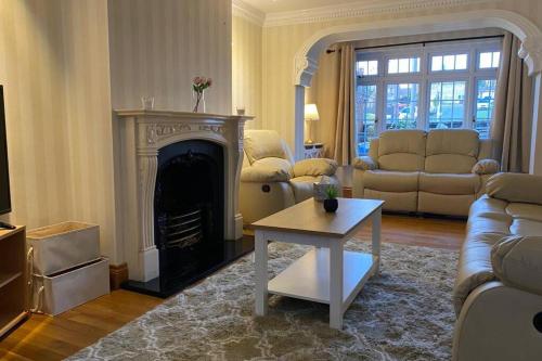 a living room with a couch and a fireplace at Comfy Home- Coley Park in Reading