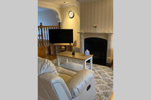 a living room with a couch and a fireplace at Comfy Home- Coley Park in Reading