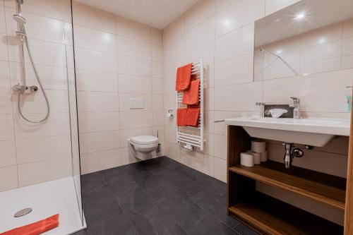 a bathroom with a shower and a sink and a toilet at Gasthof Aigner *** in Fügen