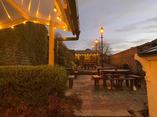 a patio with picnic tables and lights at night at The Vintage Inn in Wellington
