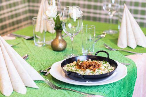 a table with a plate of food on a green table at Gasthof Aigner *** in Fügen