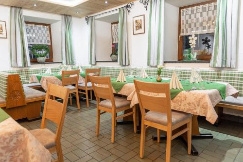 a dining room with tables and chairs and windows at Gasthof Aigner *** in Fügen