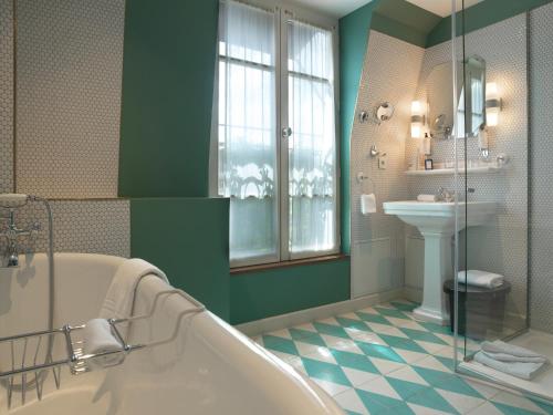 a bathroom with a tub and a sink at Hotel Bachaumont in Paris