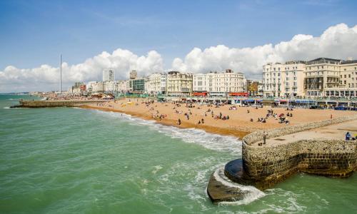 a beach with a group of people and buildings at Brighton Laines Apartments - Central Laines Location in Brighton & Hove