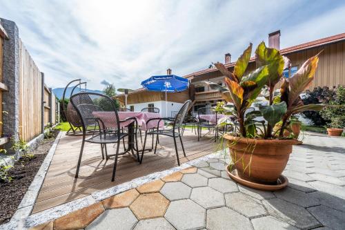 a patio with chairs and tables and a potted plant at LandererMühle in Lenggries