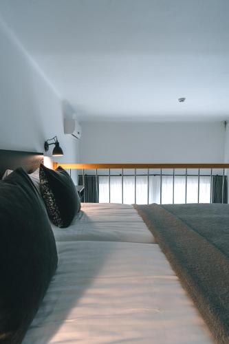 a long bed with black pillows in a room at Brother House Kaunas in Kaunas