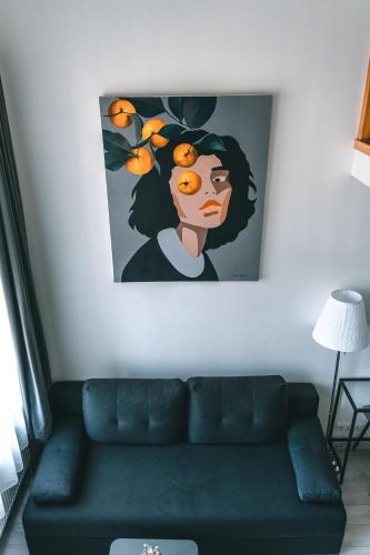 a living room with a couch and a painting on the wall at Brother House Kaunas in Kaunas