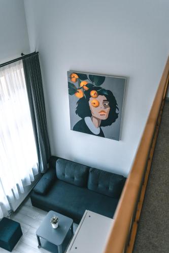 a living room with a couch and a painting on the wall at Brother House Kaunas in Kaunas