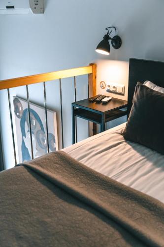 a bedroom with a bed and a desk with a lamp at Brother House Kaunas in Kaunas