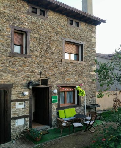 a brick house with a table and chairs in front of it at Casa Rural Fuente del Arca Montejo in Montejo de la Sierra