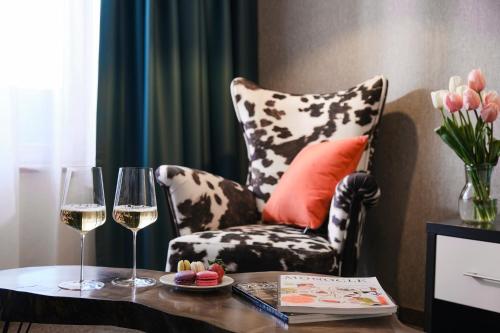 a living room with a chair and a table with wine glasses at SPA Resort St Ivan Rilski - Halfboard & All Inclusive in Bansko