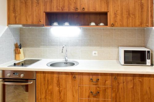 a kitchen with a sink and a microwave at SPA Resort St Ivan Rilski - Halfboard & All Inclusive in Bansko