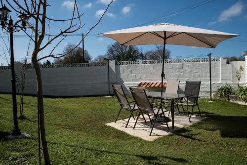 a table and chairs under an umbrella in a yard at Apartamentos Alegría in Santillana del Mar