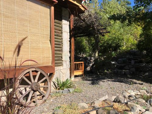 a wooden wagon outside of a house with a porch at Casa de Montaña inmersa en Bosque Nativo in San José de Maipo