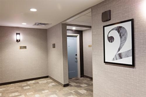 a hallway with a door and a picture on the wall at Staybridge Suites - Denver North - Thornton by IHG in Thornton