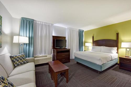 une chambre d'hôtel avec un lit et un canapé dans l'établissement Staybridge Suites London, an IHG Hotel, à London