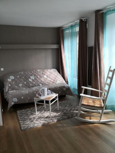 a bedroom with a bed and a table and a chair at La Ruche Cantalienne in Saint-Étienne-de-Chomeil