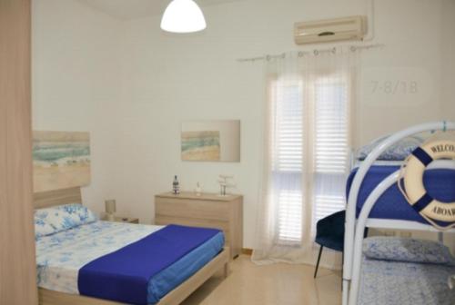 1 dormitorio con 1 cama y 1 silla en una habitación en SALENTO d' aMARE, en Torre Lapillo