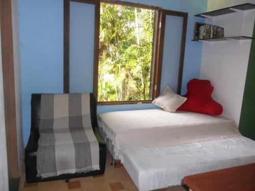 two beds in a room with a window at Sítio Cumuru in Paraty