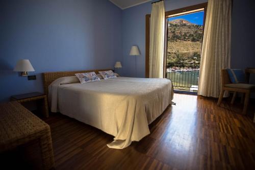 a bedroom with a bed and a large window at Hotel Cetarium in Castellammare del Golfo