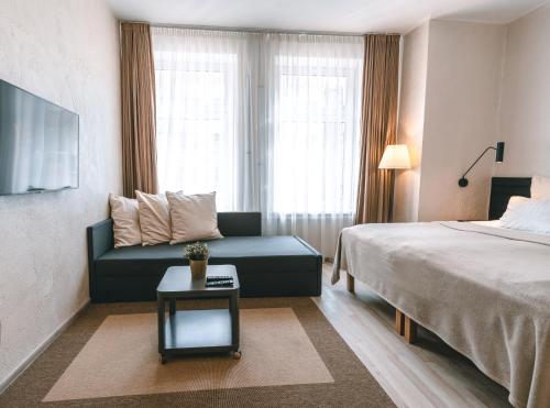 a hotel room with a bed and a couch and a table at Brother House Kaunas in Kaunas