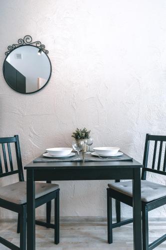a black table with two chairs and a mirror at Brother House Kaunas in Kaunas