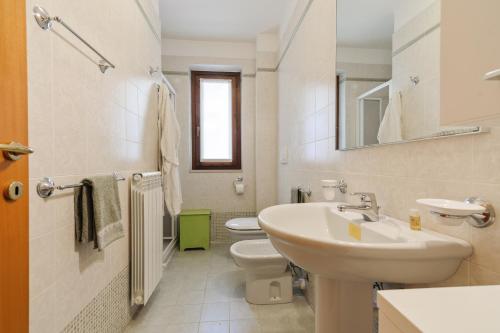 La salle de bains blanche est pourvue d'un lavabo et de toilettes. dans l'établissement Casa Selleri Terrace Apartment, à Lecce
