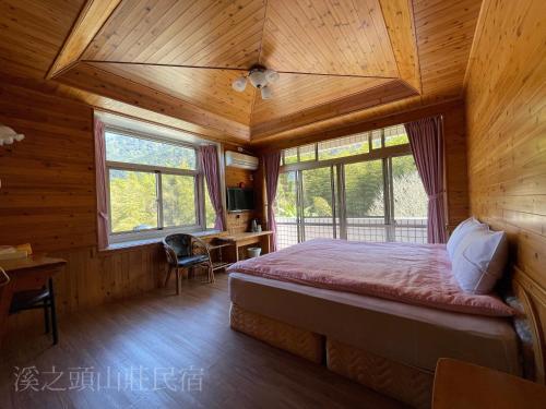 鹿谷的住宿－溪之頭山莊民宿 ，小木屋内的卧室,配有一张床和一张书桌