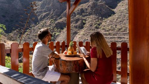 a man and a woman sitting at a table on a ride at Casas rurales de Guayadeque in Ingenio