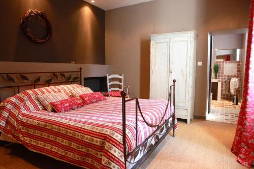 Schlafzimmer mit einem Bett mit einer roten Bettdecke in der Unterkunft Mas de la Fosse in Saint-Gilles