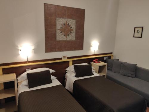 a living room with two beds and a couch at Hotel Il Rustichello in Lonato del Garda