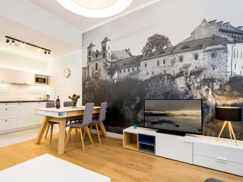 a kitchen and dining room with a tv and a table at Riverside Aparthotel Cracow in Kraków
