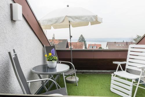 a balcony with a table and chairs and an umbrella at Ferienwohnung Maria Feucht in Überlingen