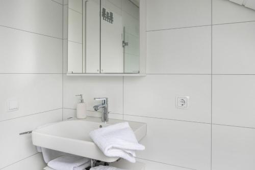 a white bathroom with a sink and a mirror at Ferienwohnung Maria Feucht in Überlingen