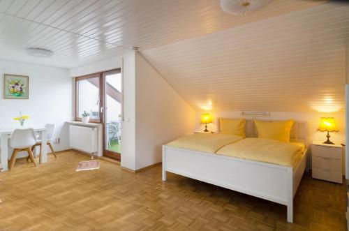 a bedroom with a white bed with yellow pillows at Ferienwohnung Maria Feucht in Überlingen