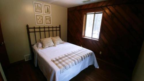 a bedroom with a bed with a window and a bed sidx sidx sidx at Avenwood Cabins in Logan
