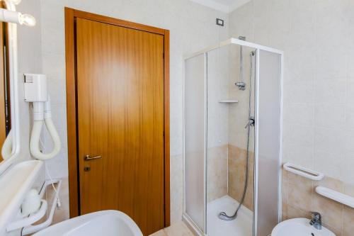 een badkamer met een toilet en een glazen douche bij Tamerici Lido Altanea in Caorle