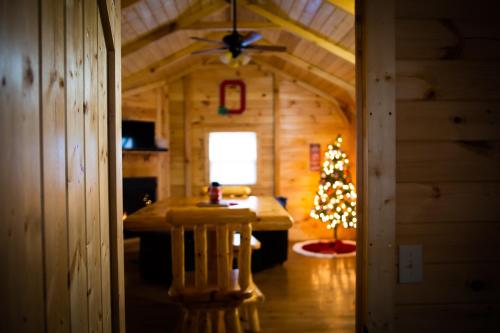 a hallway of a cabin with a christmas tree in it at Avenwood Cabins in Logan