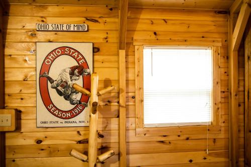 a log cabin with a sign on the wall at Avenwood Cabins in Logan