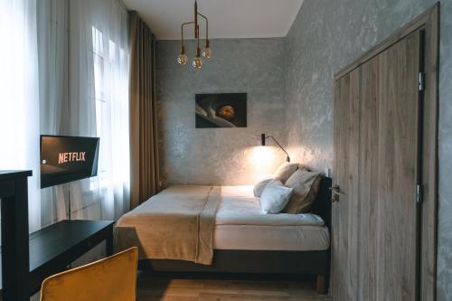 a bedroom with a bed with a desk and a window at Brother House Kaunas in Kaunas