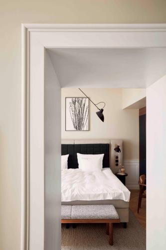 a bedroom with a white bed with a black headboard at Villa Copenhagen in Copenhagen