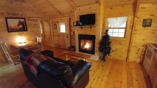 a living room with a fireplace in a log cabin at Avenwood Cabins in Logan