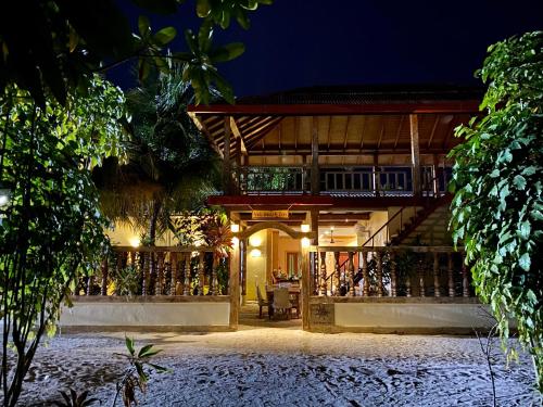 a resort building with a balcony at night at Veli Beach Inn in Mathiveri