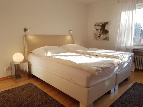 ein weißes Bett in einem Zimmer mit Fenster in der Unterkunft Fewo am Wald in Balve