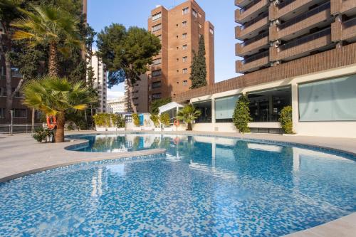 a large swimming pool in a city with tall buildings at Aparthotel BCL Levante Club in Benidorm