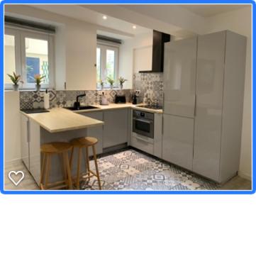 une cuisine avec des armoires blanches et une table et des chaises dans l'établissement Marais, 2 pièces luxueux rénové, près rue Bretagne, à Paris