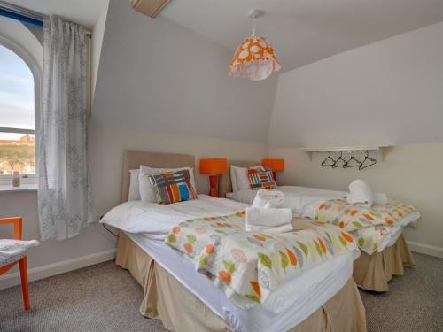 a bedroom with two twin beds and a window at The Old Auction Rooms Lot 2 Central with Private Parking in Whitby